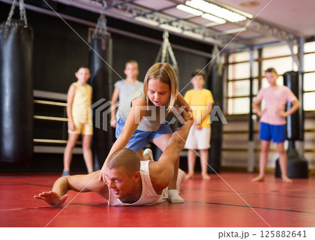 Girl practice self-defense techniques on trainer 125882641