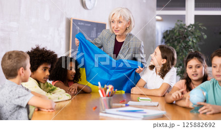 students listen to woman teacher who talks about Ukraine 125882692