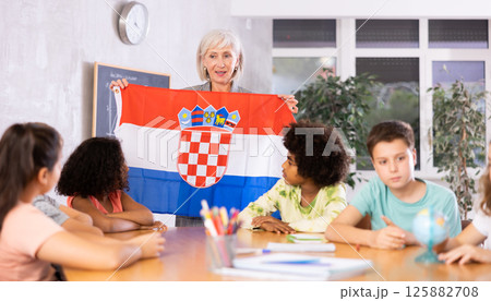 Female teacher showing croatian flag to kids in geography class 125882708