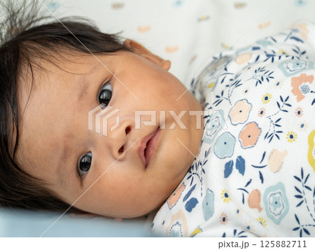 Newborn asian baby captured in cozy home environment close-up heartwarming lifestyle moment 125882711