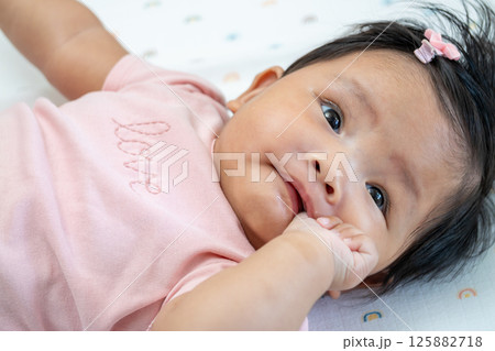 Newborn asian baby smiling in cozy nursery candid moment indoor peaceful setting Newborn asian baby smiling in cozy nursery candid moment indoor peaceful setting 125882718