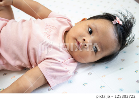 Newborn baby girl in pink cozy home setting asian infant portrait tender moments 125882722