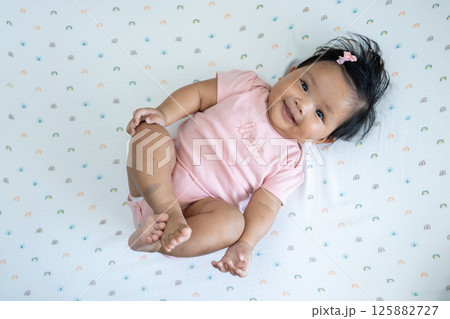 Joyful newborn baby girl asian heritage playful portrait home setting close-up celebrating life Joyful newborn baby girl asian heritage playful portrait home setting close-up celebrating life 125882727