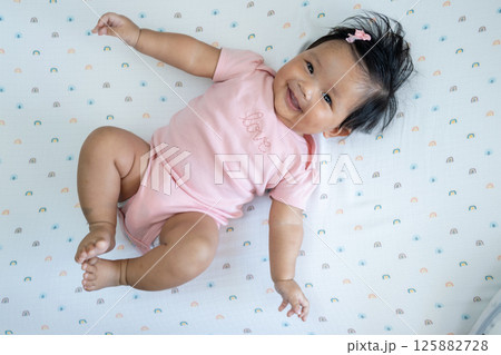 Joyful baby newborn smiling colorful blanket indoor cheerful atmosphere 125882728