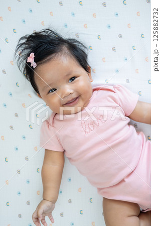 Joyful newborn asian baby with cute smile cozy home setting baby 125882732