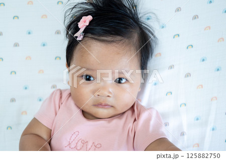 Newborn baby girl asian heritage portrait soft lighting close-up innocence captured 125882750