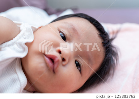 Newborn baby girl asian infant close-up cozy home setting innocent expression Newborn baby girl asian infant close-up cozy home setting innocent expression 125882762