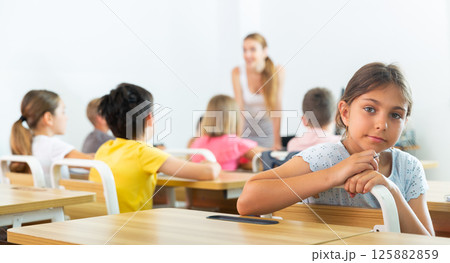 Schoolgirl sitting in classroom during lesson in elementary school Schoolgirl sitting in classroom during lesson in elementary school 125882859