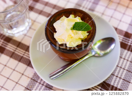 Delicate flan dessert is served in miniature bowl decorated with leaf of fragrant fresh mint Delicate flan dessert is served in miniature bowl decorated with leaf of fragrant fresh mint 125882870