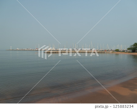 Serene coastal view of a marina calm waters landscape scenic environment Serene coastal view of a marina calm waters landscape scenic environment 125883234