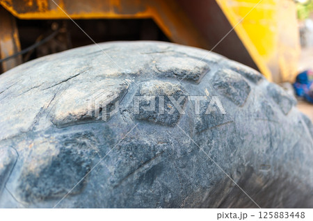 Heavy machinery action close-up of tire tread in industrial site 125883448