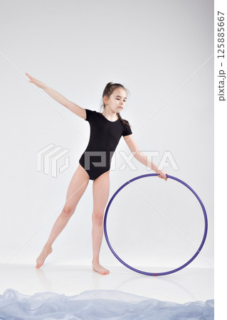 A girl in a swimsuit and a dress shows beautiful athletic elements on a white background. Ballet, rhythmic gymnastics, fabric, aesthetics, grace. High quality photo A girl in a swimsuit and a dress shows beautiful athletic elements on a white background. Ballet, rhythmic gymnastics, fabric, aesthetics, grace. High quality photo 125885667