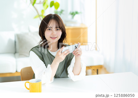 部屋でスマホを操作する若い女性 部屋でスマホを操作する若い女性 125886050