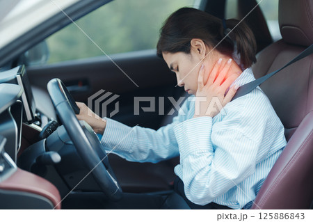 woman with her shoulder and neck sprain while driving car long time, muscle painful. Shoulder ache, Scapular pain, office syndrome and ergonomic concept woman with her shoulder and neck sprain while driving car long time, muscle painful. Shoulder ache, Scapular pain, office syndrome and ergonomic concept 125886843