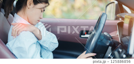 woman with her shoulder and neck sprain while driving car long time, muscle painful. Shoulder ache, Scapular pain, office syndrome and ergonomic concept 125886856