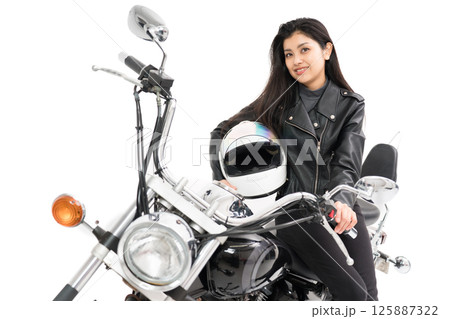 レザージャケットを着てバイクに座ってヘルメットを持つバイク女子 レザージャケットを着てバイクに座ってヘルメットを持つバイク女子 125887322