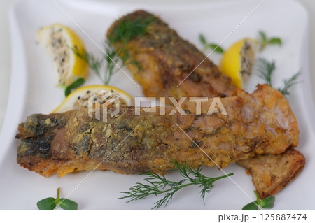 Grilled fish with roasted potatoes and vegetables on plate Grilled fish with roasted potatoes and vegetables on plate 125887474