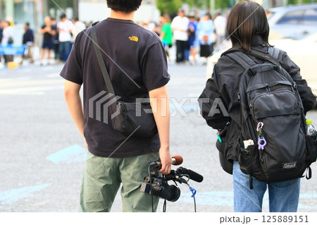 歩行者天国でインタビューを取るTV局のスタッフ カメラマンとディレクター 歩行者天国でインタビューを取るTV局のスタッフ カメラマンとディレクター 125889151