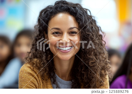 Smiling woman with curly hair in a classroom, wearing a yellow sweater and gray shirt. Concept of happiness and positivity. For personal or educational content. Smiling woman with curly hair in a classroom, wearing a yellow sweater and gray shirt. Concept of happiness and positivity. For personal or educational content. 125889276