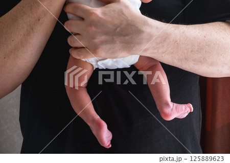 Man Holding Newborn Baby in Tender Moment 125889623