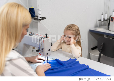 Cute little girl spending time with her mom in a designers studio 125890093