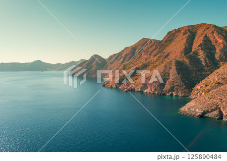 Mountain landscape with rocky seascape. Aerial panoramic view to the west from El Portus and Morena beach. Murcia, Spain Mountain landscape with rocky seascape. Aerial panoramic view to the west from El Portus and Morena beach. Murcia, Spain 125890484