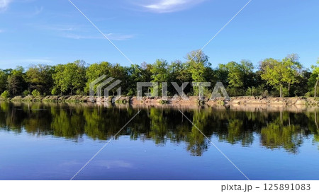 river and forest. Beautiful landscape the river bank is surrounded by forest. Steep sandy beach. Lake in the forest river and forest. Beautiful landscape the river bank is surrounded by forest. Steep sandy beach. Lake in the forest 125891083