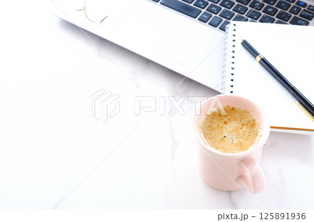淹れたての美味しいコーヒー、カフェ・ラッテを飲みながら、ノートパソコンでデスクワーク中のイメージ 淹れたての美味しいコーヒー、カフェ・ラッテを飲みながら、ノートパソコンでデスクワーク中のイメージ 125891936