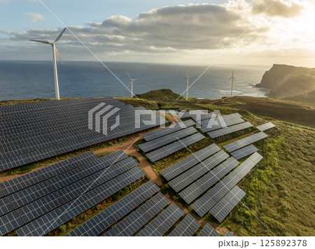 Solar energy panels photovoltaic cell and wind power plants on the seashore landscape for production of renewable green energy 125892378