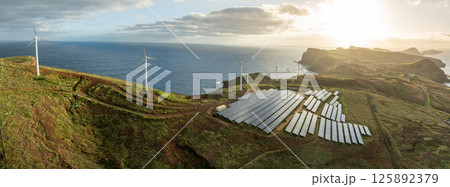 Solar energy panels photovoltaic cell and wind power plants on the seashore landscape for production of renewable green energy 125892379