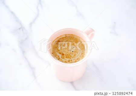 エスプレッソと牛乳を混ぜたカフェ・ラッテを飲みながらリラックスしているイメージ エスプレッソと牛乳を混ぜたカフェ・ラッテを飲みながらリラックスしているイメージ 125892474