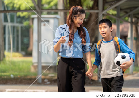 Back to School and Soccer Excitement. A mother and son bond over soccer after school. 125892929