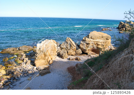 Beautiful landscape of the Black Sea. The natural coastline of the Odessa Bay consists of shell rock and clay against which the sea waves break. 125893426