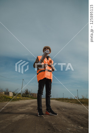 Architect Walking And Watching On The Construction Site With The Map In His Hands  125895115