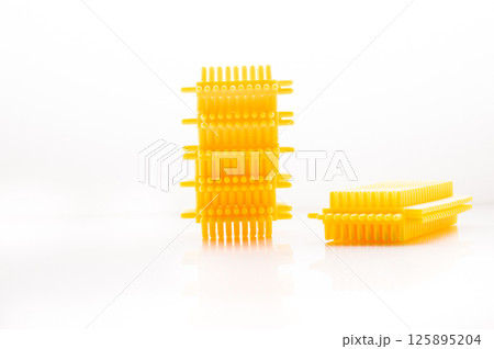 The children's construction set is presented in the form of yellow blocks arranged on a bright background. The children's construction set is presented in the form of yellow blocks arranged on a bright background. 125895204