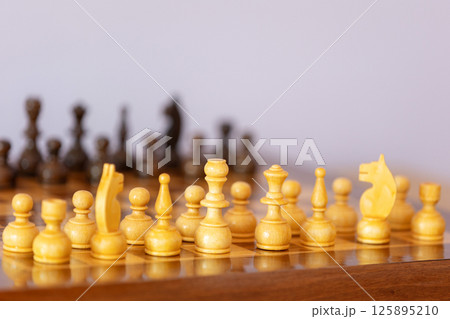 Wooden white chess pieces on the chessboard 125895210