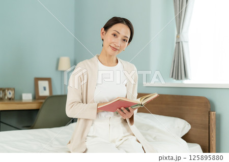 ベッドルームで読書をする女性 ベッドルームで読書をする女性 125895880