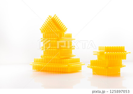 The children's construction set is made in warm yellow colors. The white background enhances the visual appeal of the details.  125897053
