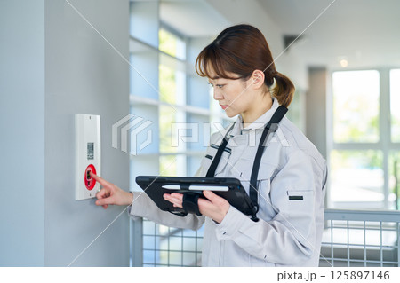 非常警報設備を点検する女性 125897146