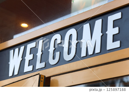 Welcome sign above the entrance to the cafe, white letters on a black background Welcome sign above the entrance to the cafe, white letters on a black background 125897188