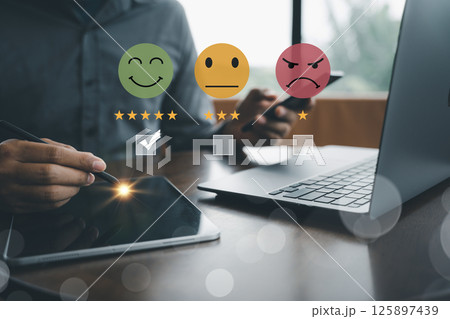 Customer satisfaction and service quality survey being conducted by businessman using a virtual screen to measure feedback through smiley face icon with the highest level. Result is a positive review Customer satisfaction and service quality survey being conducted by businessman using a virtual screen to measure feedback through smiley face icon with the highest level. Result is a positive review 125897439
