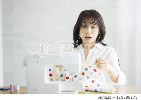 自宅で洋裁をする女性 125898178