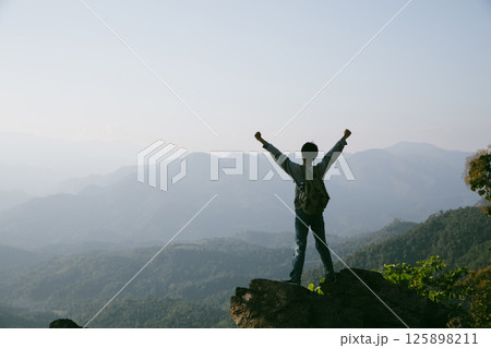 Man traveler with camera backpack hiking outdoor travel lifestyle and adventure concept. cap backpack and join of tourist for green mountain tour, beauty of nature and expansive sky people of tourism Man traveler with camera backpack hiking outdoor travel lifestyle and adventure concept. cap backpack and join of tourist for green mountain tour, beauty of nature and expansive sky people of tourism 125898211