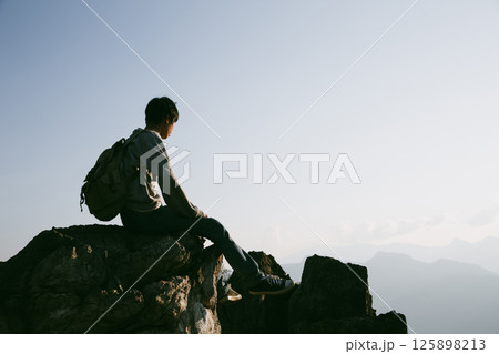 Man traveler with camera backpack hiking outdoor travel lifestyle and adventure concept. cap backpack and join of tourist for green mountain tour, beauty of nature and expansive sky people of tourism 125898213