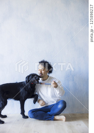 愛犬とくつろぐ男性 125898217