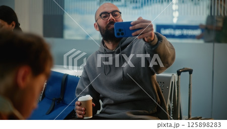 Airport Terminal: Popular Travel Blogger Filming Video Content Using Smartphone 125898283