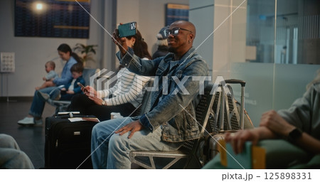 Man Talking by Video Chat, Filming Video Content Using Smartphone in Airline Hub Lounge 125898331