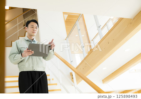 住宅の引き渡し　アフターメンテナンスをする作業着の男性 125898493