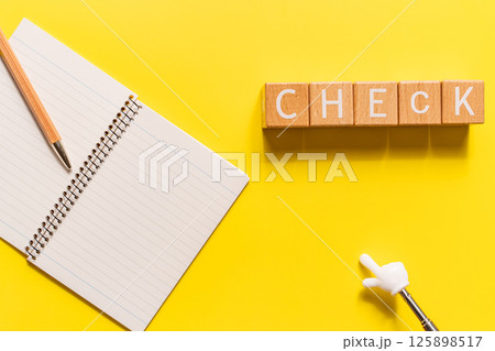 CHECKの文字ブロックとノート、指差し棒の黄色背景イメージ 125898517