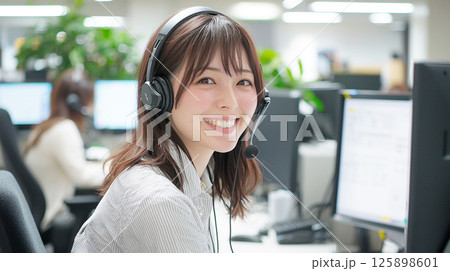 ヘッドセットで応対する笑顔の女性オペレーター ヘッドセットで応対する笑顔の女性オペレーター 125898601